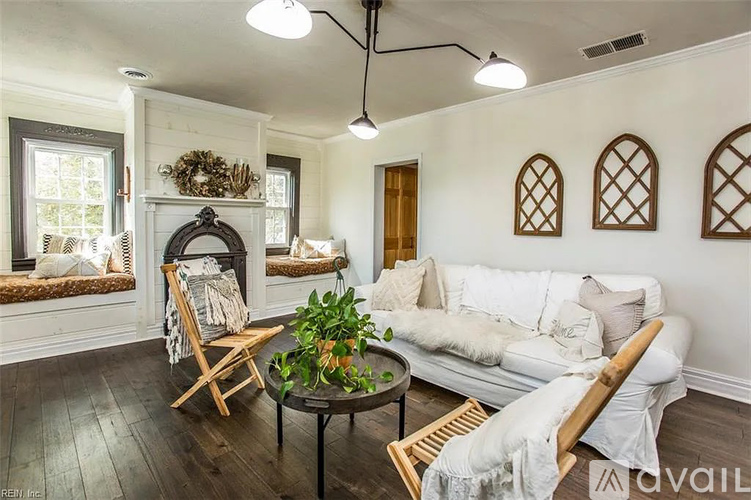A living room with a white couch, a coffee table, and a fireplace.