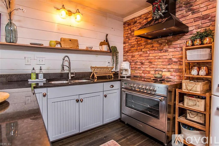 A kitchen with a brick wall and a stove top oven.