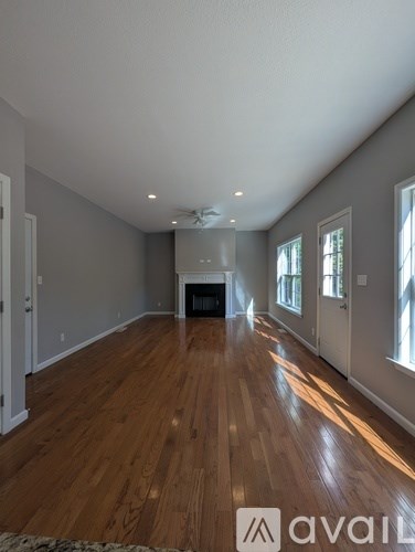 A living room with wood flooring and a fireplace.