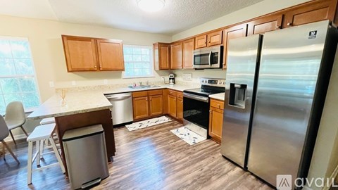 A kitchen with wooden cabinets and a stainless steel refrigerator.