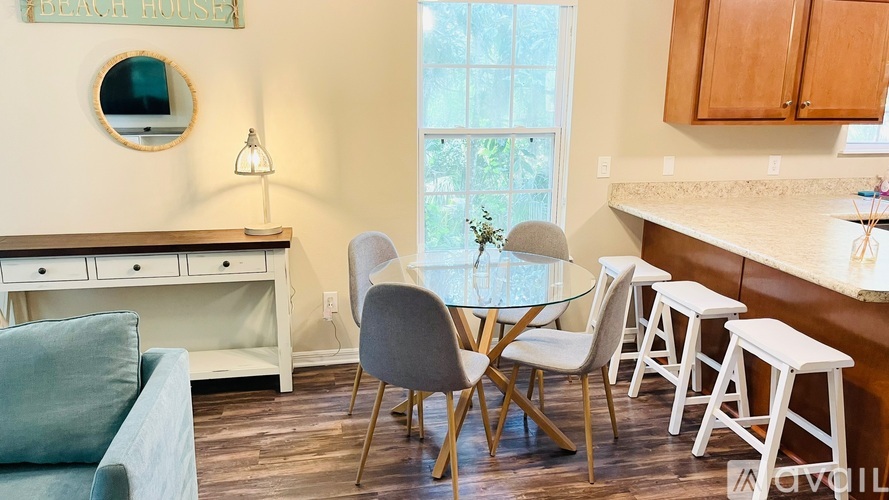 A dining room with a glass table and chairs.