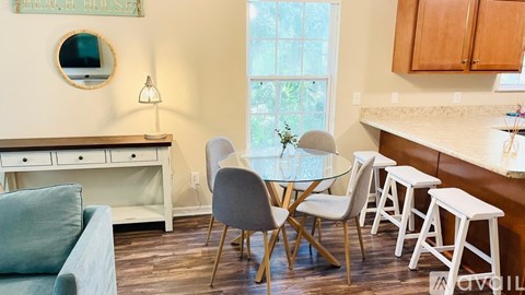 A dining room with a glass table and chairs.