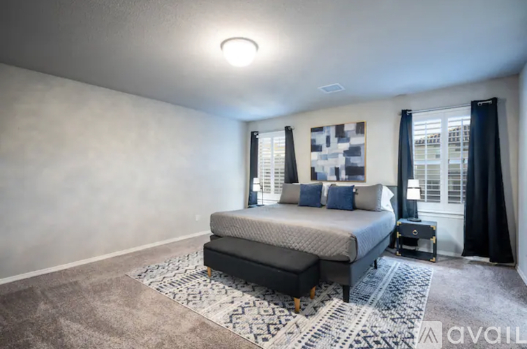A bedroom with a large bed and a rug on the floor.