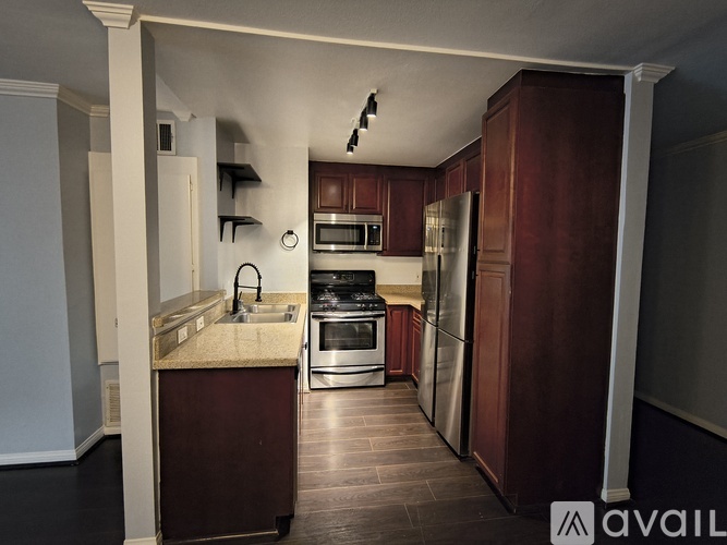 A kitchen with dark wood cabinets and stainless steel appliances.