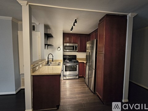 A kitchen with dark wood cabinets and stainless steel appliances.
