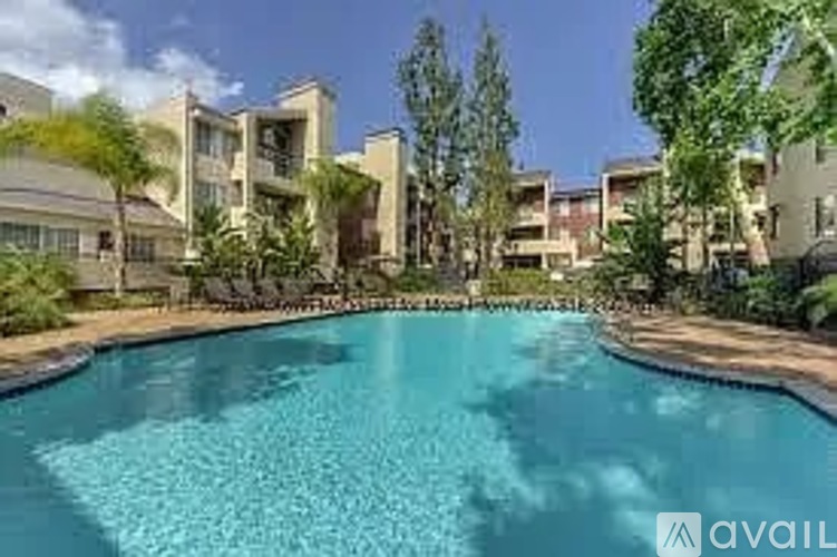 A swimming pool surrounded by trees and buildings.
