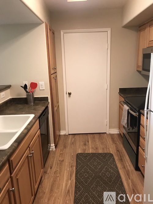 A kitchen with wooden cabinets and a white door.