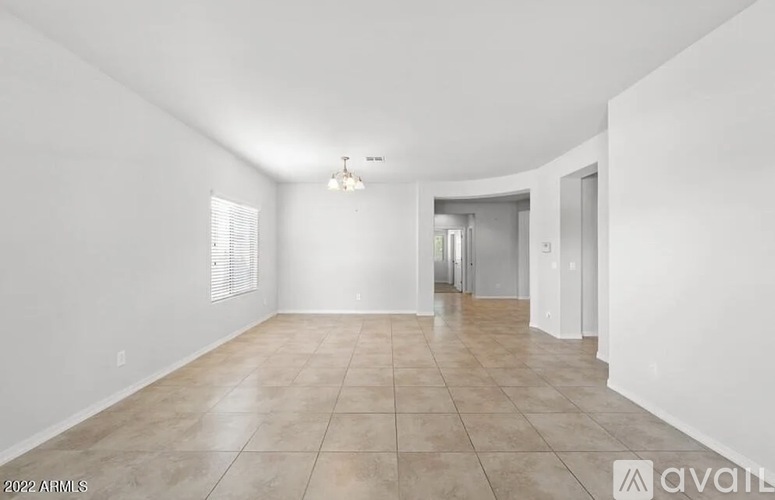 A spacious room with tiled flooring and white walls.