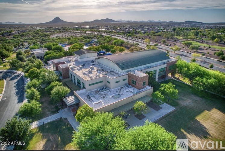An aerial view of a building surrounded by trees with a mountain in the distance.