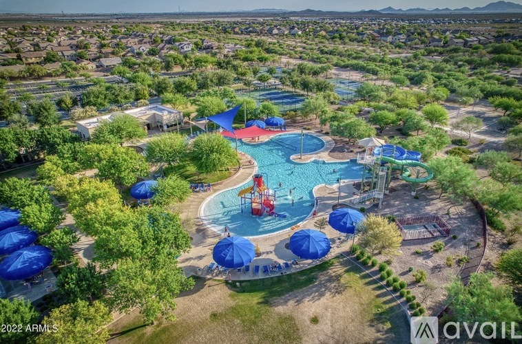 An aerial view of a pool surrounded by trees and umbrellas.