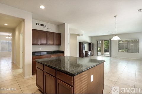 A kitchen with brown cabinets and a black countertop.