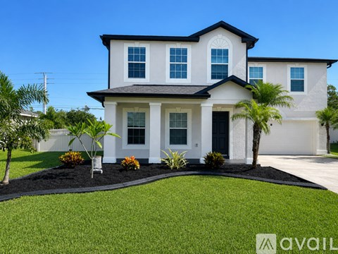 A modern house with a well-manicured lawn and landscaping.