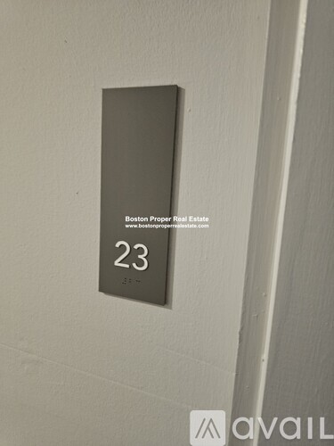 A sign on a wall that says "Boston Proper Real Estate" and the number 23.