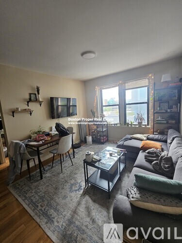 A living room with a couch, a chair, a coffee table, and a dining table.