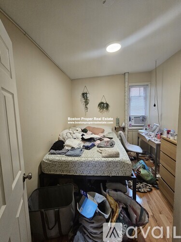 A bedroom with a bed, desk, and chair.