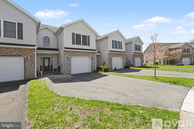 A row of houses with a driveway in front.