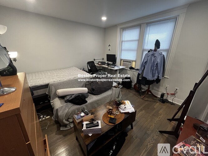 A room with a bed, a desk, and a chair.