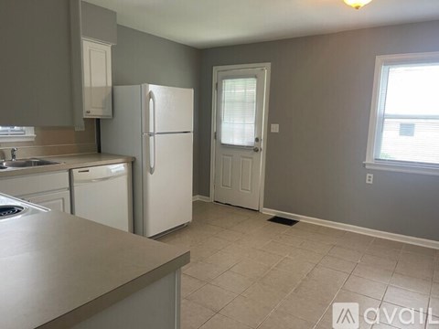 A kitchen with a white refrigerator and a sink.