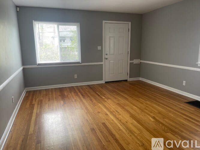 A room with wooden flooring and a white door.