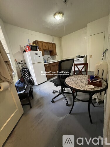 A kitchen area with a table and chairs in the foreground.