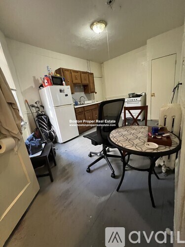 A kitchen area with a table and chairs in the foreground.