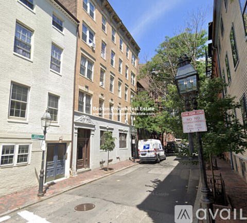 A street view of a residential area with a "NO PARKING ANYTIME" sign.