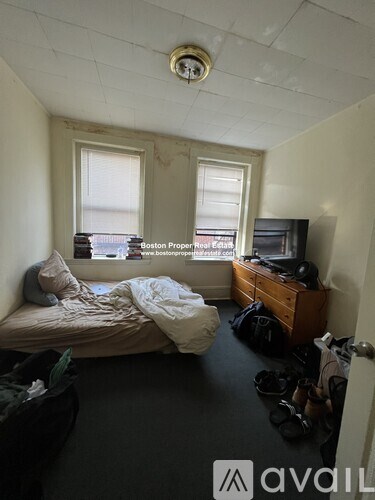 A bedroom with a bed, dresser, and window.
