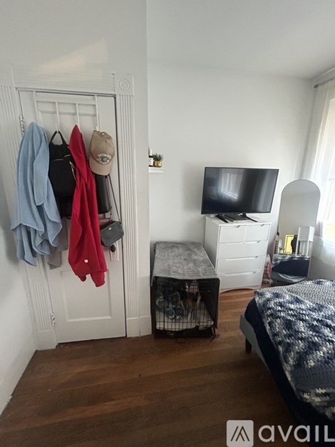 A bedroom with a bed, a TV, a wardrobe and a chair.
