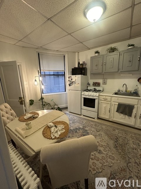 A kitchen with a table and chairs in front of a window.
