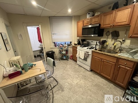 A kitchen with a white stove top oven and a microwave above it.