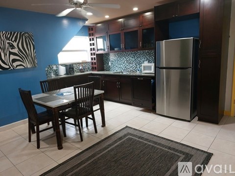A kitchen with a table and chairs.
