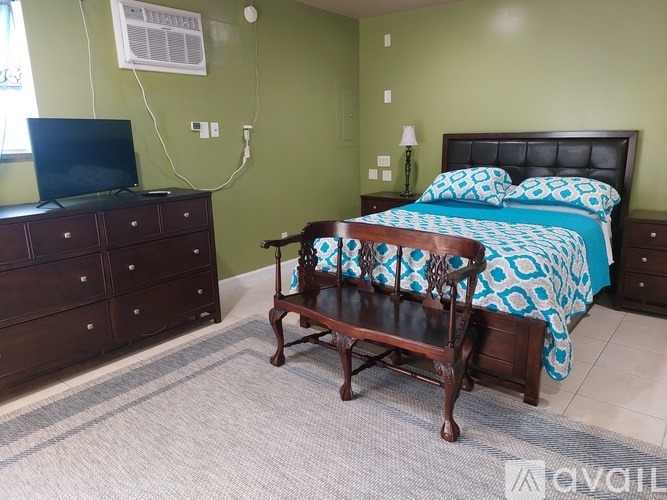 A bedroom with a bed, dresser, and chair.