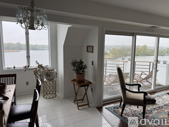 A dining room with a table and chairs and a view of the water.