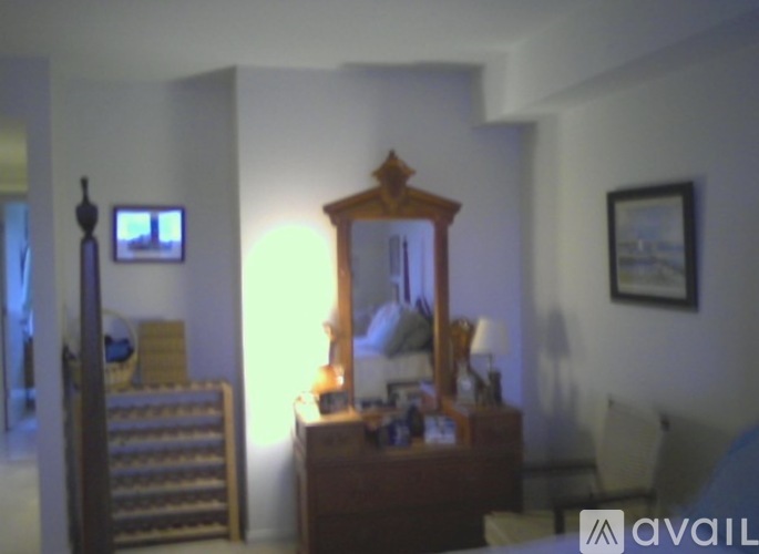 A bedroom with a mirror and a TV on the wall.