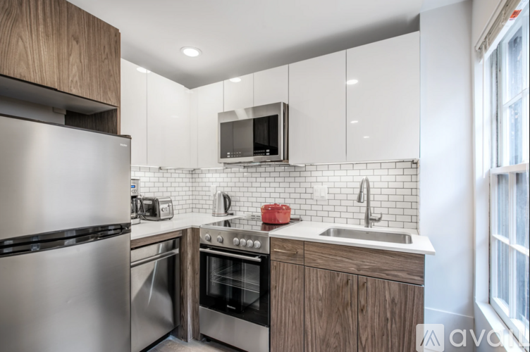 A modern kitchen with stainless steel appliances and wooden cabinets.
