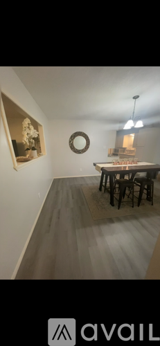 A room with a table and chairs and a painting on the wall.