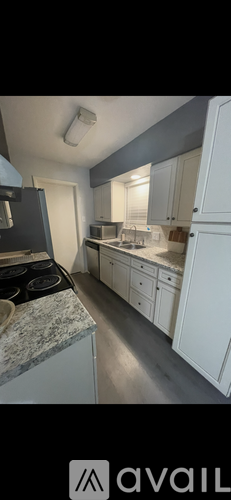 A kitchen with white cabinets and a granite countertop.