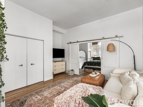 A living room with a white couch and a rug.