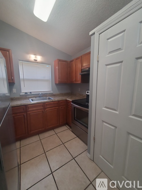 A kitchen with brown cabinets and a white door.