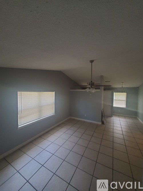 A room with a ceiling fan and tiled flooring.