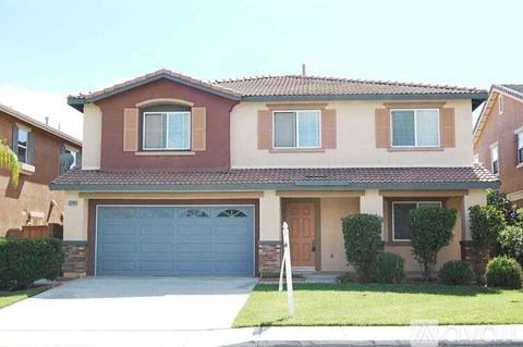 A house with a brown roof and a blue garage door.