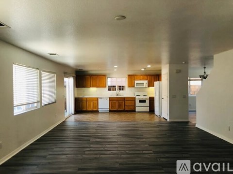 A spacious kitchen with wooden cabinets and a white refrigerator.