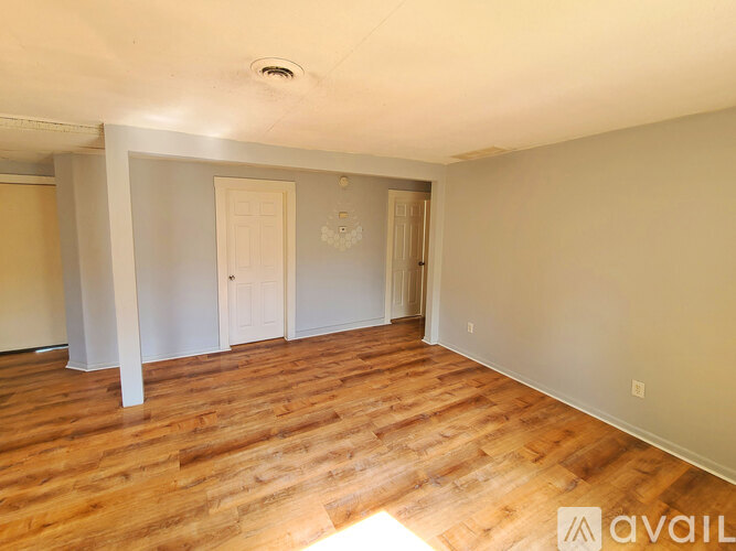 A room with wooden flooring and two doors.