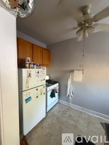 A kitchen with a fridge and a ceiling fan.