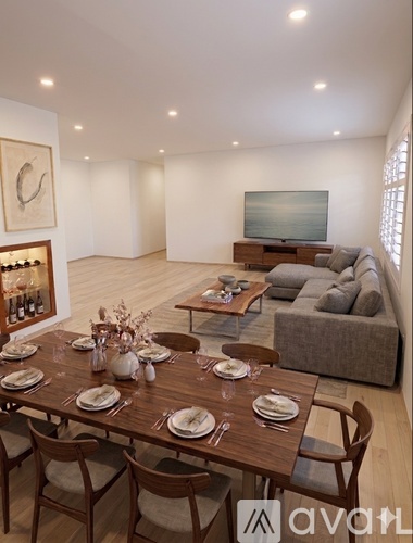 A dining room with a wooden table set for a meal.