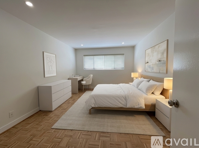 A bedroom with a large bed, a desk, and a chair.