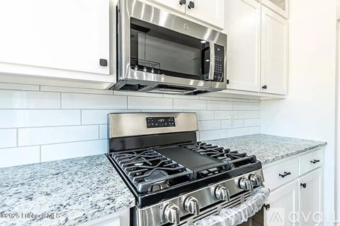 A modern kitchen with a stainless steel stove and microwave above it.
