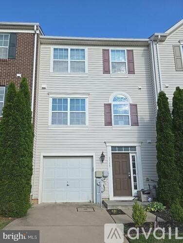 A two-story house with a garage and a driveway.