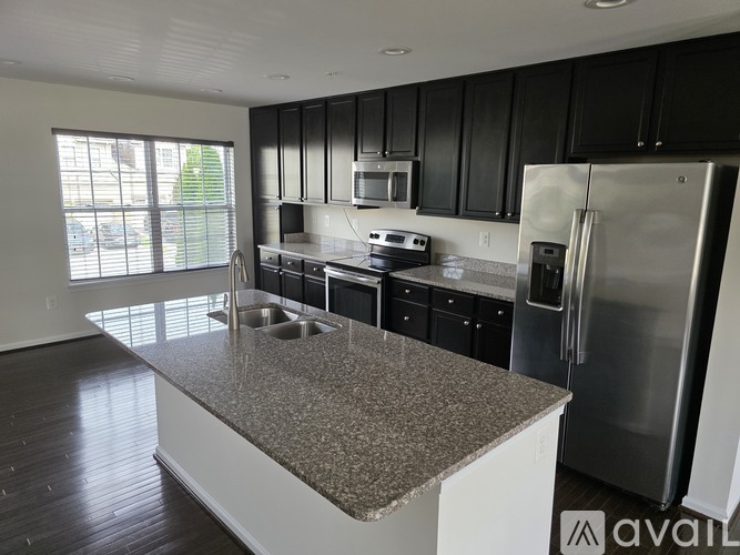 A kitchen with black cabinets and stainless steel appliances.