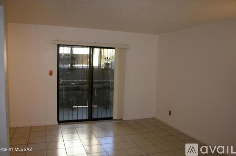 A room with a sliding glass door and tiled floor.